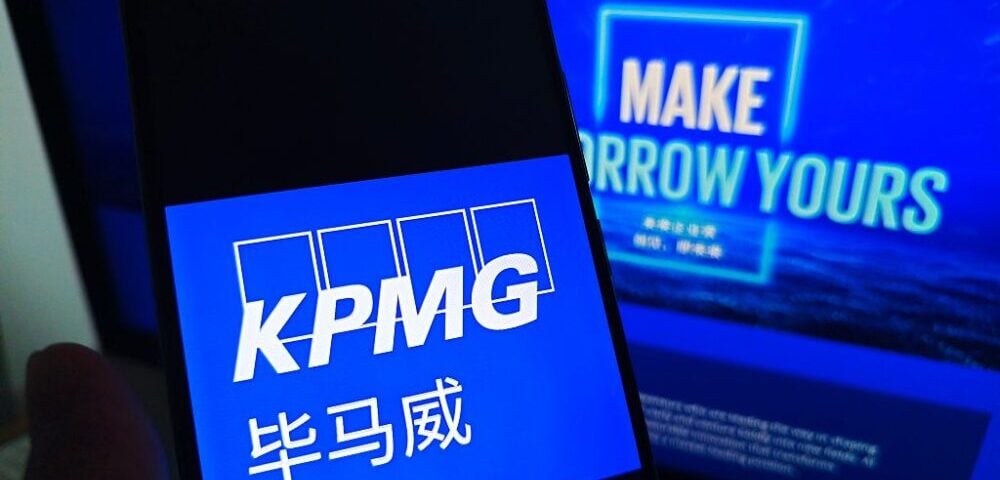 Article Image - Best AI Tools KPMG logo on a smartphone screen with Chinese text beneath, blue background and a blurred blue poster in the background.
