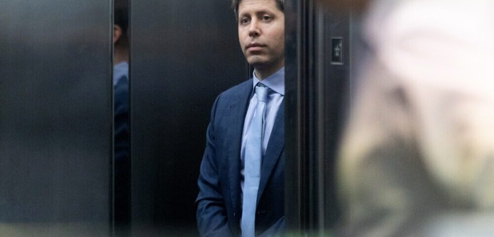 Article Image - Best AI Tools Man in a blue suit and tie standing in an elevator, looking toward the camera.