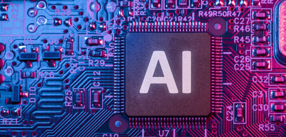 Article Image - Best AI Tools Close-up of a microprocessor with 'AI' on the chip, surrounded by pink and blue circuit board lighting.