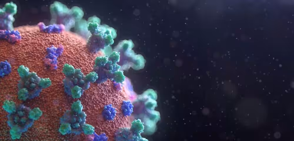 Close-up of a virus particle with green and blue spike proteins on a red surface, set against a dark background.